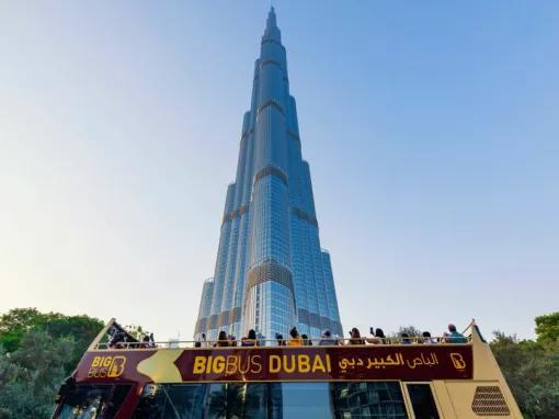 Guests on the top deck of a Big Bus Dubai Sightseeing bus taking photos of the Burj Khalifa