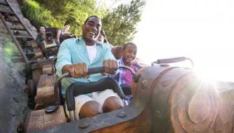Guests riding Seven Dwarfs Mine Train at Magic Kingdom