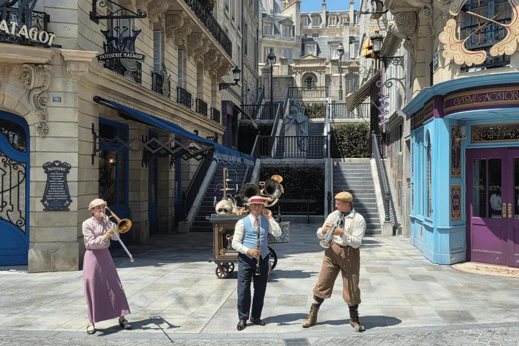 The Wizarding World of Harry Potter Empty streets of Paris with three musicians wearing old fashioned outfits playing different instruments including trumpets and clarinettist.