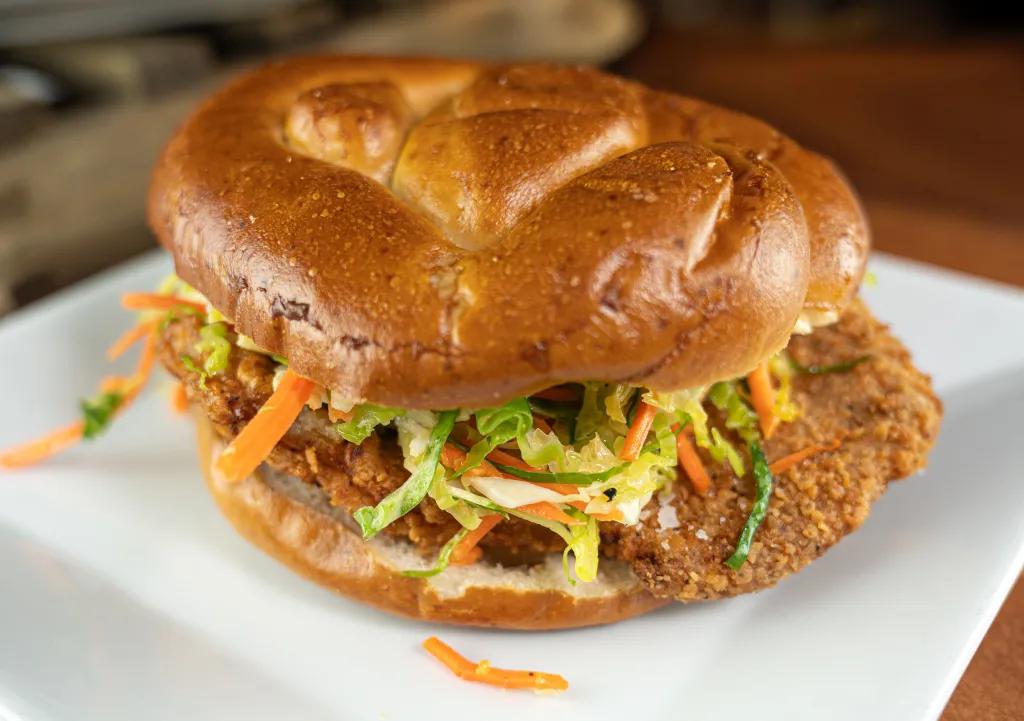 Pork Schnitzel Sandwich A pork schnitzel sandwich with coleslaw on a plate