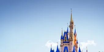 Es ist das Cinderella Schloss im Magic Kingdom Park im Walt Disney World Resort in Florida abgebildet. Der Himmel ist strahlend blau. 