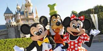 Micky, Minnie und Goofy posieren vor dem Dornröschenschloss in Disneyland Kalifornien