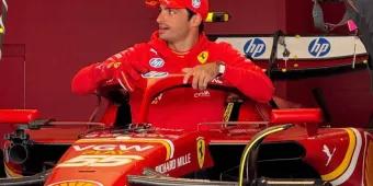 Famous Ferrari driver hopping in his famous Formula 1 Ferrari car in the garage with red walls. He is wearing a red cap which is branded and is wearing a red hoodie with the Ferrari logo on it.