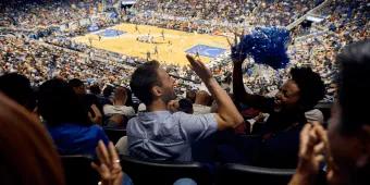 Two friends high-fiving while watching an Orlando Magic game