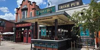 Raglan Road at Disney Springs An irish pub with a sign saying Raglan Road Irish Pub, there is a bar and multiple bar stools.