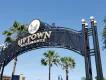 Uptown Altamonte An iron overhead sign for Uptown Altamonte in front of palm trees and a blue sky