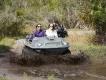 Orlando Revolution Adventures Two people sat side by side in a mucky duck 4x4 vehicle driving into water