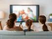 US TV Favorites A woman, a teenager and a young girl watching TV from a sofa