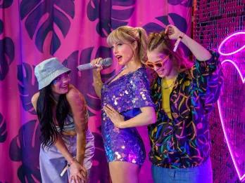 Two women posing with a Taylor Swift waxwork at Madame Tussauds London