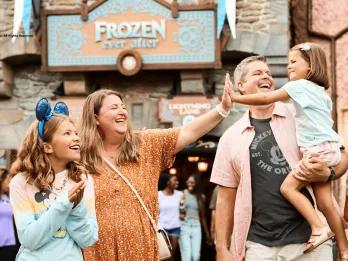 A family high-fiving while walking away from the Frozen Ever After Ride at Disney World
